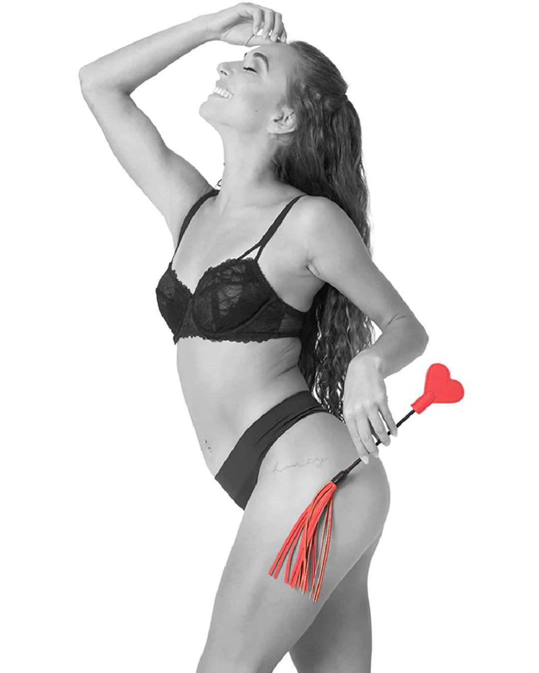 Side view of model holding Sex & Mischief Amor Red Heart Crop and Flogger