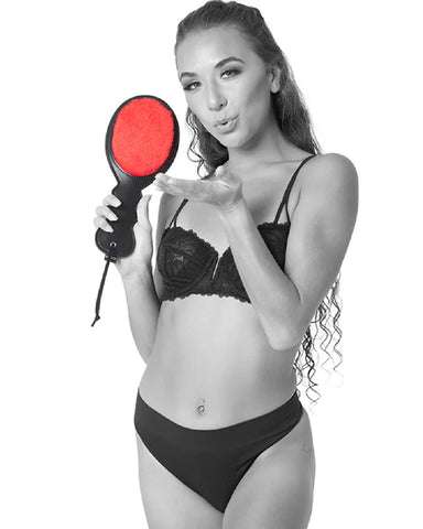 Model blowing a kiss and holding Sex & Mischief Amor Red Paddle